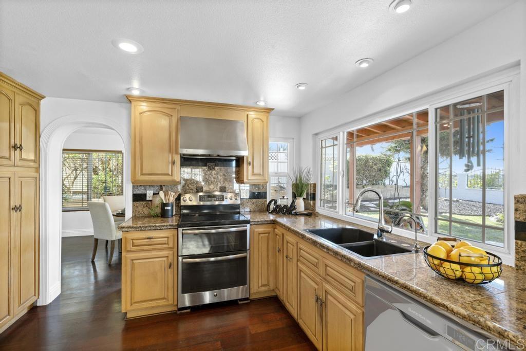 978 Roca Place Chula Vista, CA 91910 - Photo 14 of 45 a kitchen with stainless steel appliances granite countertop a sink a stove and a refrigerator