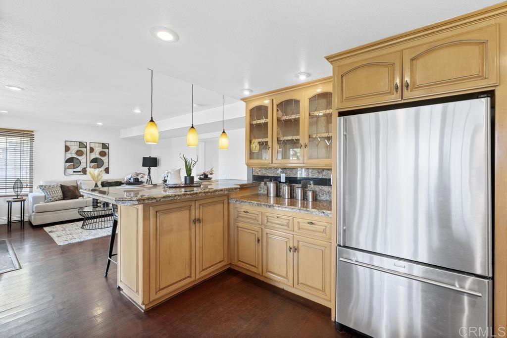 978 Roca Place Chula Vista, CA 91910 - Photo 18 of 45 a kitchen with stainless steel appliances granite countertop a refrigerator a oven and white cabinets with wooden floors