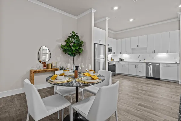 a view of a dining room with furniture a chandelier and wooden floor