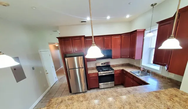 a kitchen with stainless steel appliances granite countertop a refrigerator a stove a sink and a refrigerator