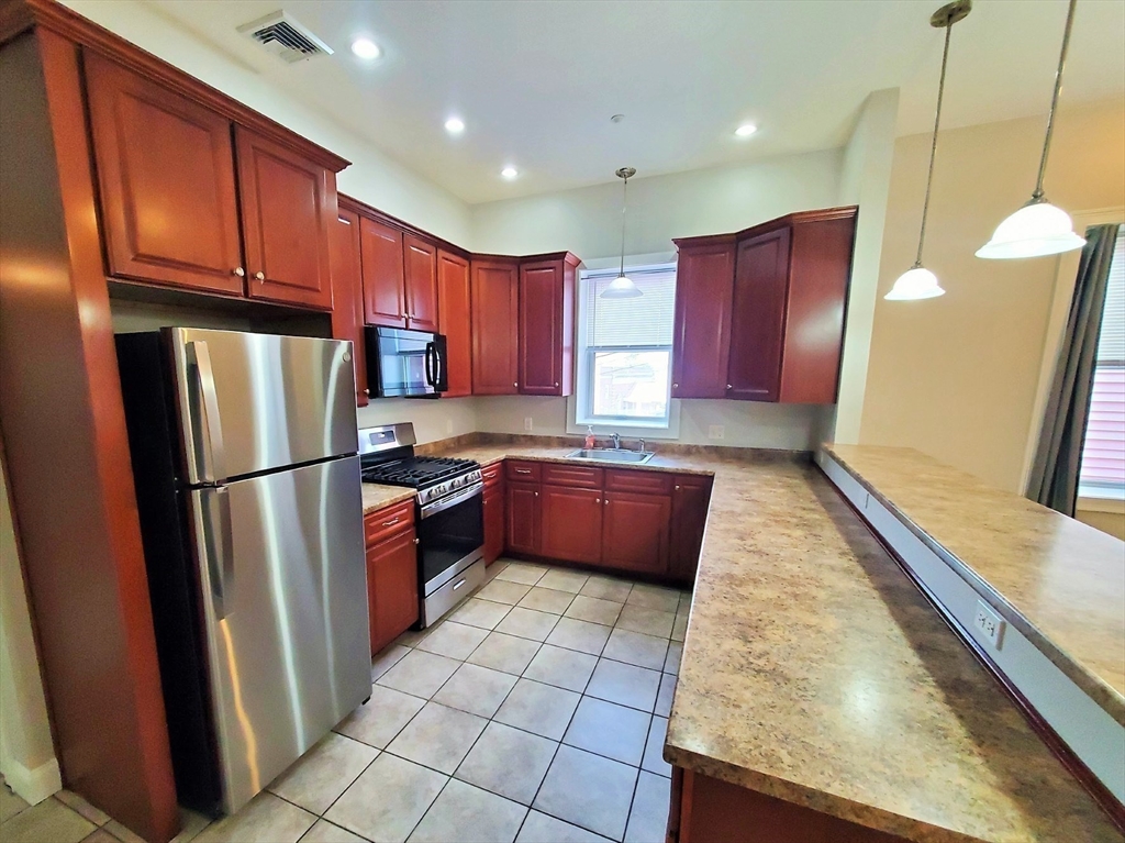 37 Central Square, Unit 37B Bridgewater, MA 02324 - Photo 2 of 15 a large kitchen with stainless steel appliances granite countertop a refrigerator a sink a stove a microwave and island