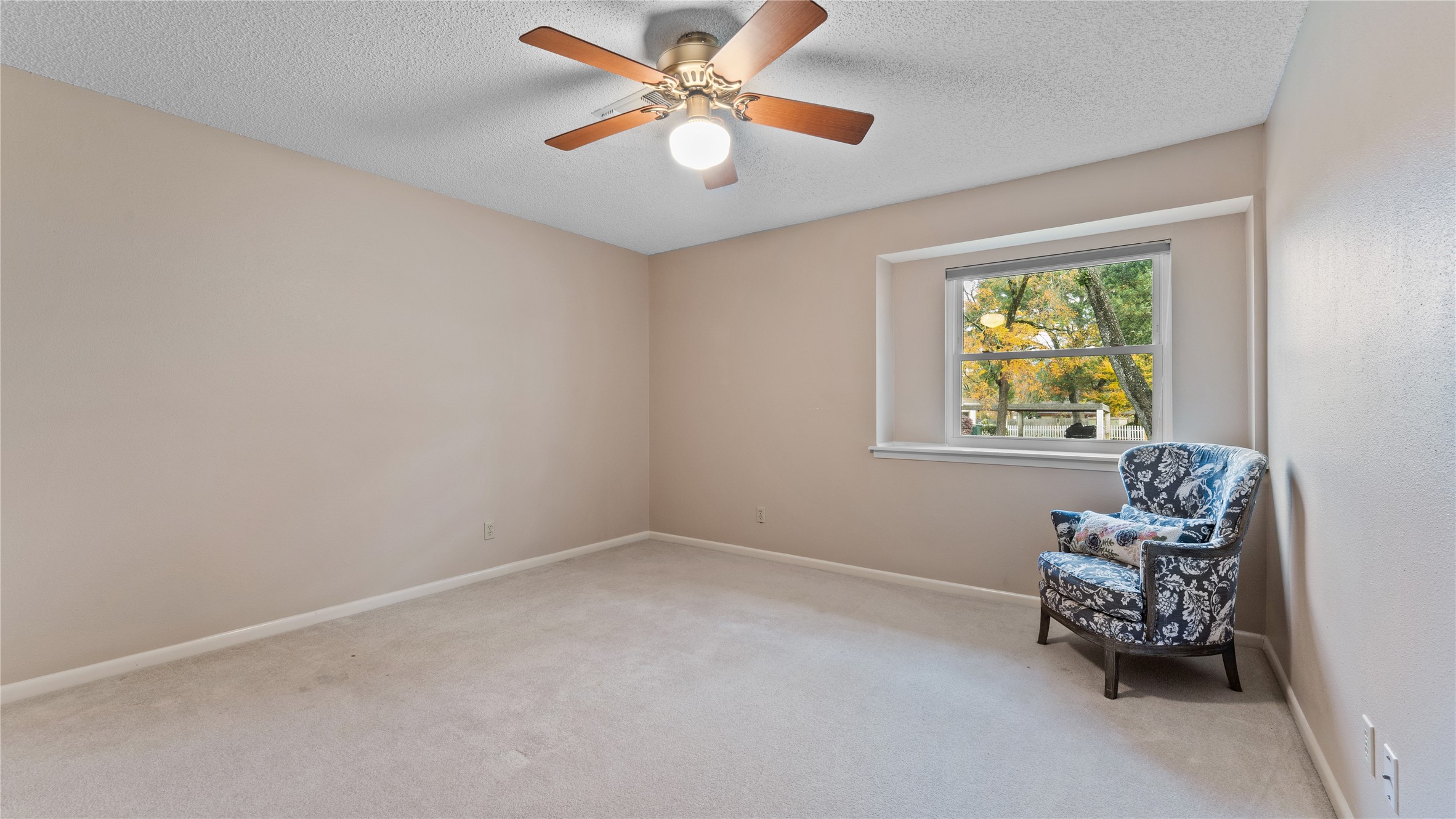 208 Magnolia Way Huntsville, TX 77320 - Photo 19 of 26 This room features neutral walls and carpet, a ceiling fan, and a window with a view of the front yeard.