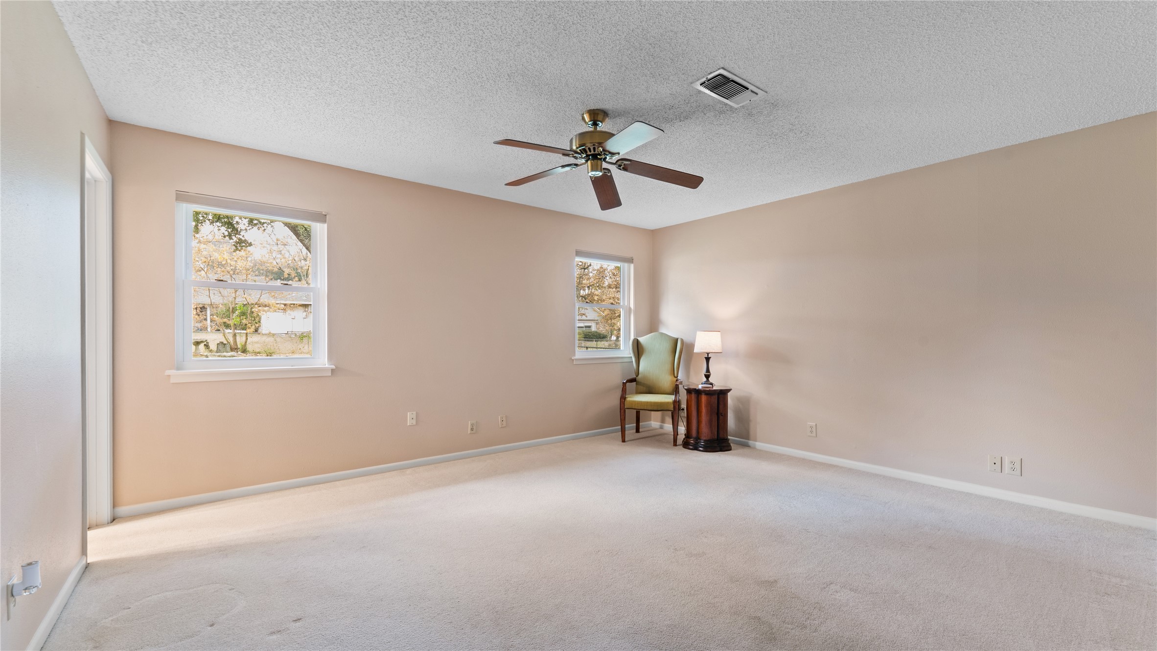 208 Magnolia Way Huntsville, TX 77320 - Photo 20 of 26 The primary bedroom is large and has a ceiling fan with new windows looking into the backyard.
