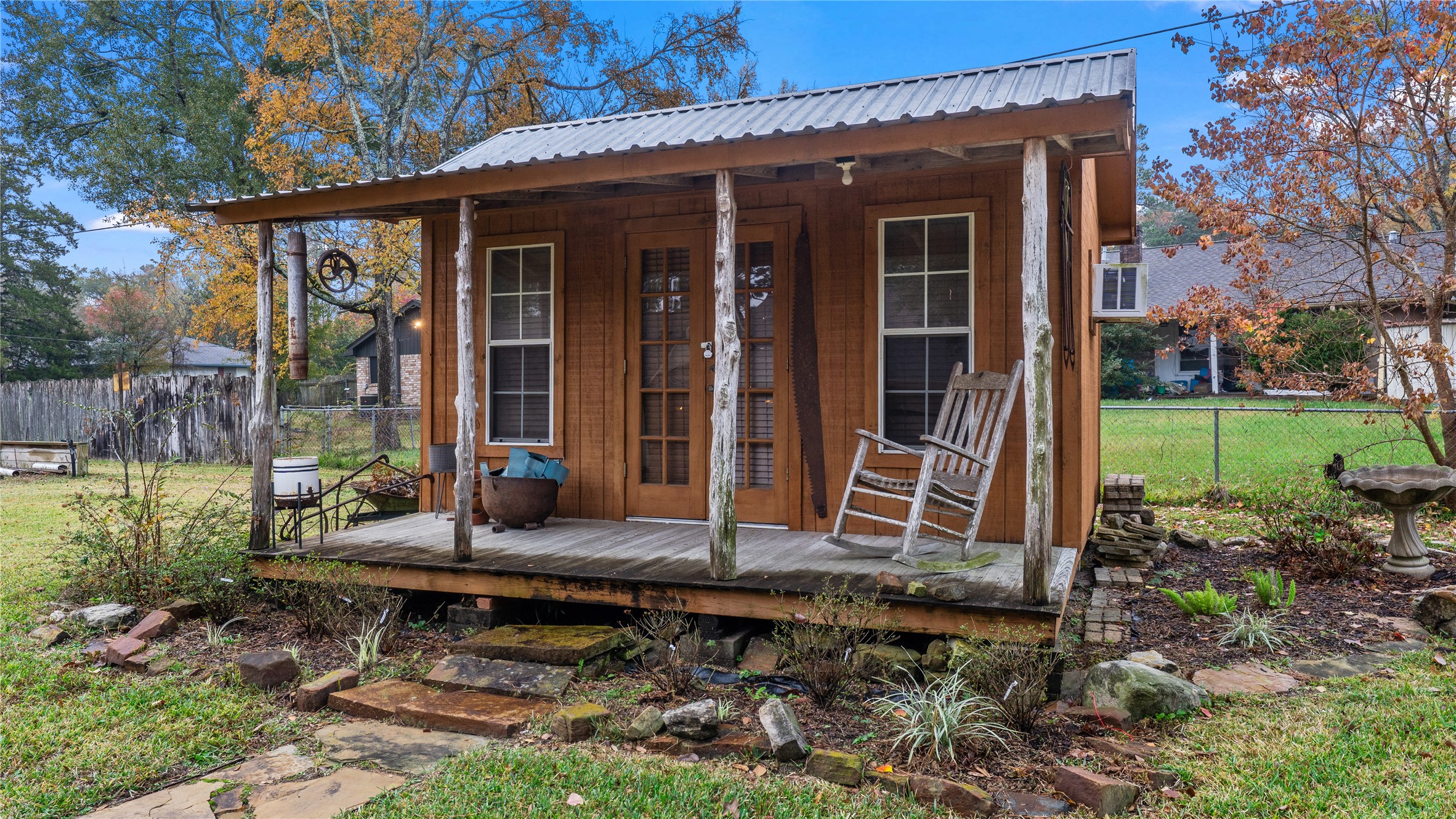 208 Magnolia Way Huntsville, TX 77320 - Photo 23 of 26 Charming rustic shed with a small porch and rocking chair, set in a spacious yard. Surrounded by a mix of grass and mature trees, it offers a cozy retreat vibe, office, playhouse, or allow your creative side to come out. This can be used for many purposes.