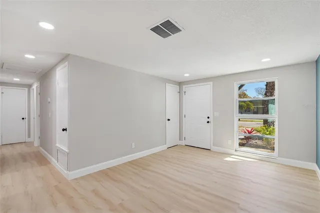 a view of a kitchen from a hallway with wooden floor and a kitchen
