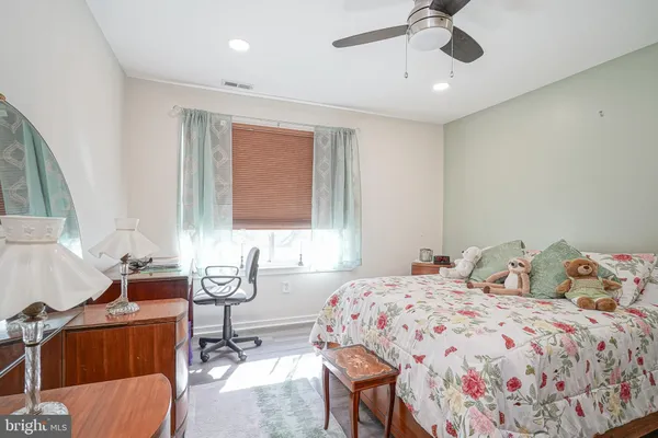 a bedroom with a bed and dresser with mirror