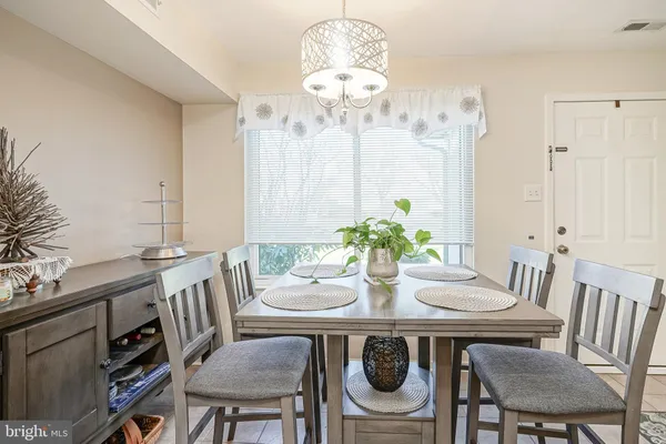 a view of a dining room with furniture a chandelier and wooden floor