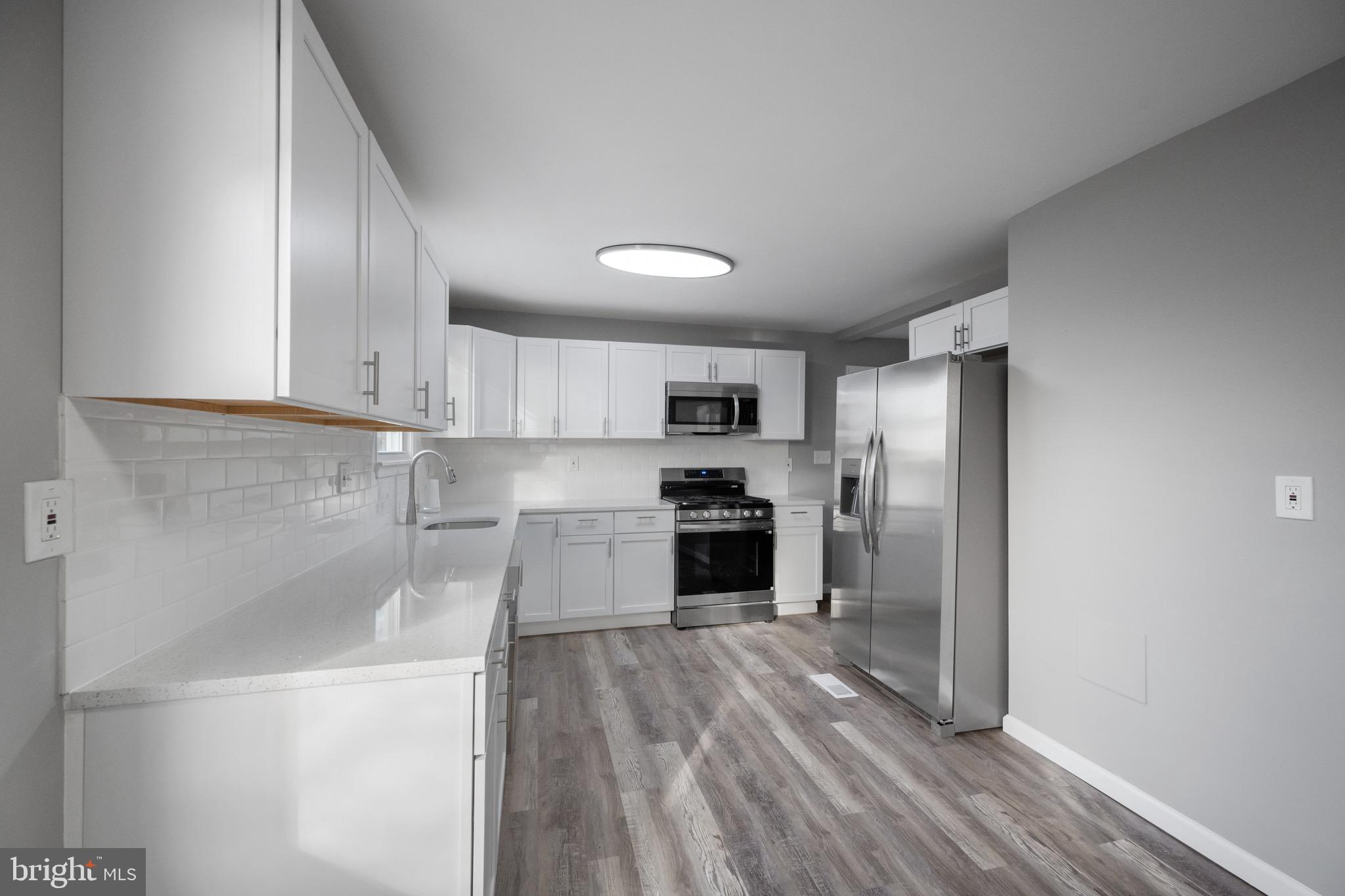 3401 Court Way Baltimore, MD 21222 - Photo 29 of 35 a kitchen with granite countertop stainless steel appliances a refrigerator and a stove top oven