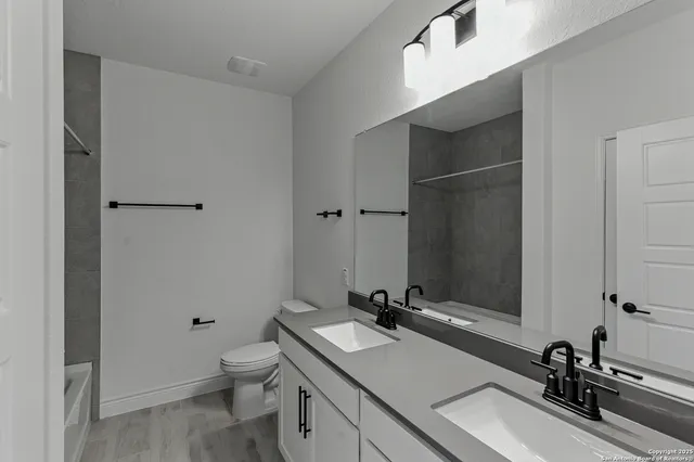 a bathroom with a sink a toilet and mirror