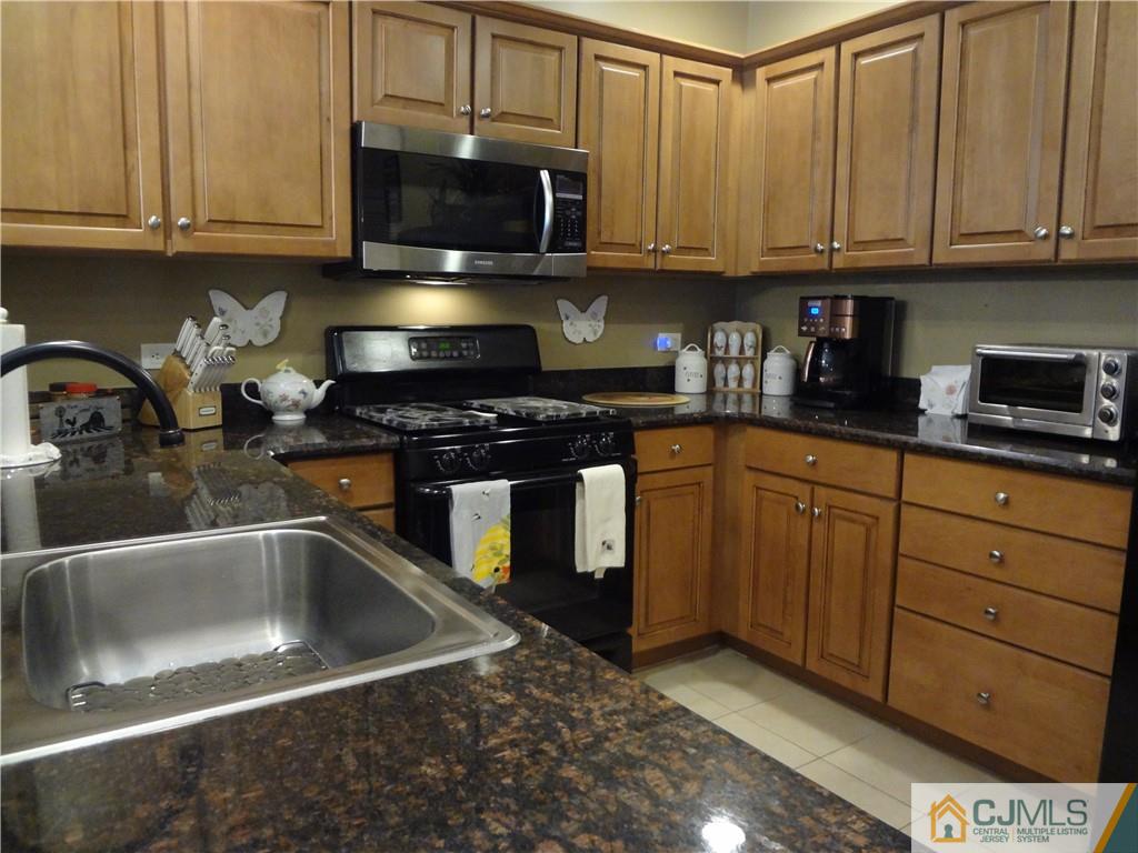 368 Rector Street, Unit 304 Perth Amboy, NJ 08861 - Photo 13 of 23 a kitchen with granite countertop a sink and cabinets