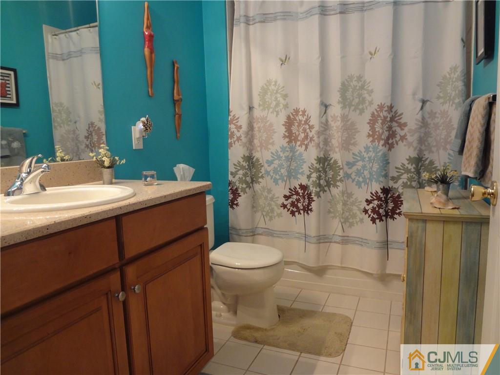 368 Rector Street, Unit 304 Perth Amboy, NJ 08861 - Photo 22 of 23 a bathroom with a toilet sink and mirror