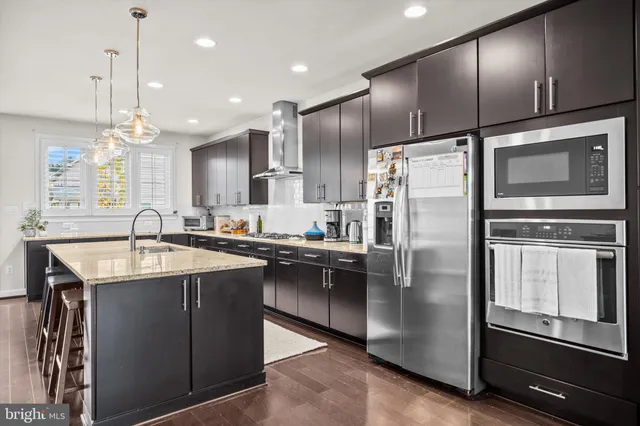 a kitchen with stainless steel appliances granite countertop a sink a stove and a refrigerator