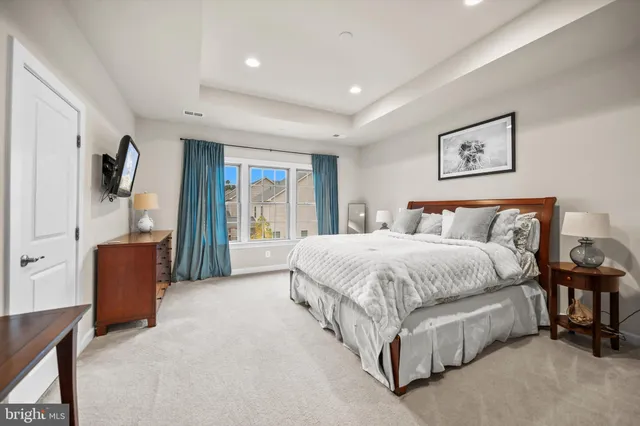 a spacious bedroom with a large bed and a chandelier