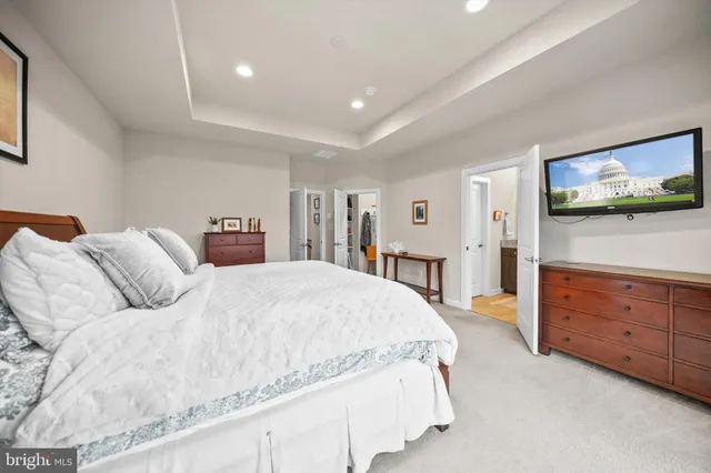 a spacious bedroom with a bed and a flat screen television