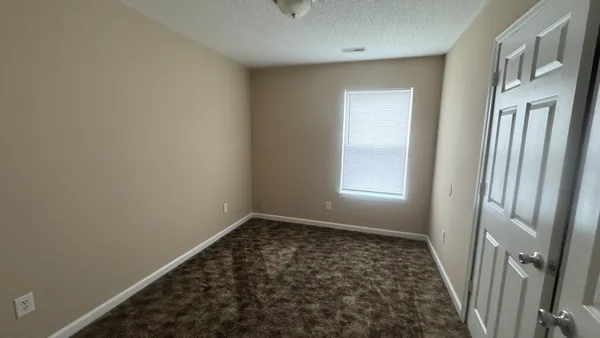 a view of a hallway with wooden floor and a window