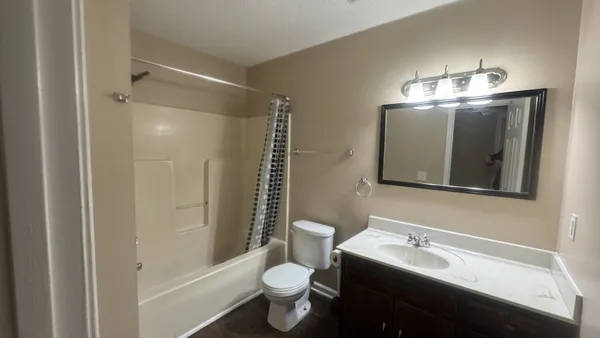 a bathroom with a sink toilet a mirror and shower