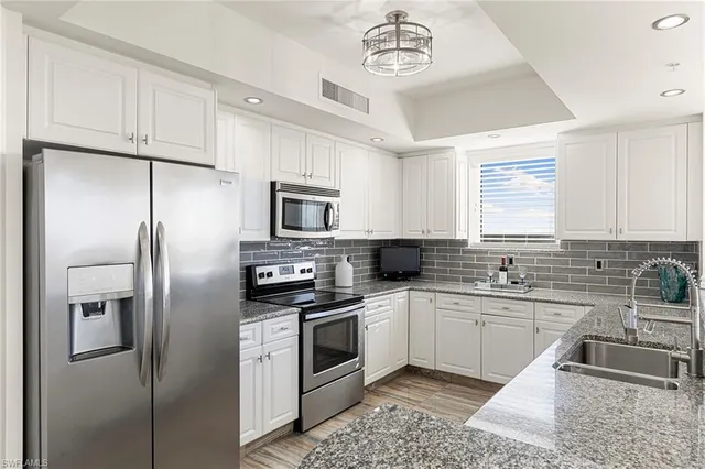 a bathroom with a granite countertop sink a toilet a mirror and shower