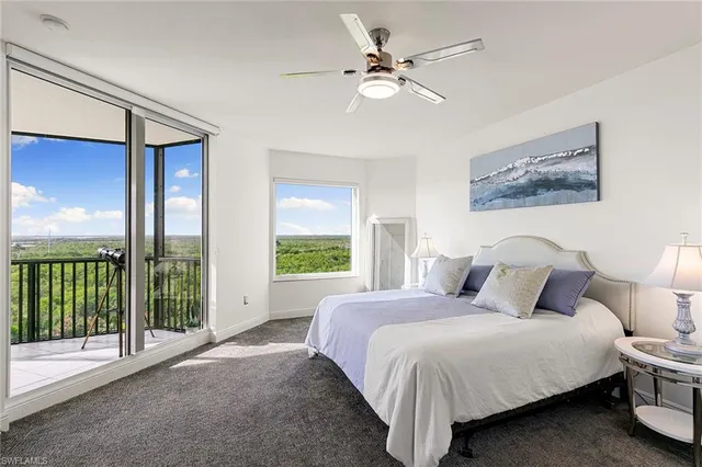 a living room with couch a large window and a chandelier