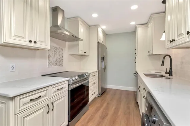 a kitchen with stainless steel appliances granite countertop a sink stove and refrigerator