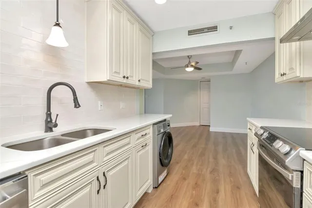 a kitchen with a sink and a stove top oven