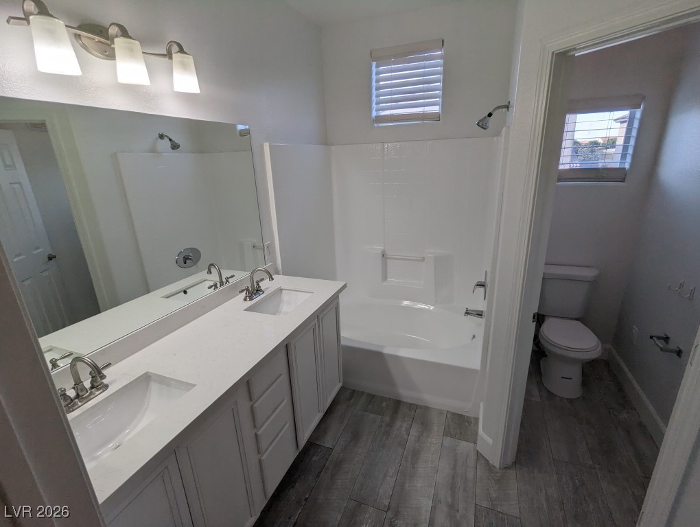 9303 Gilcrease Avenue, Unit 1137 Las Vegas, NV 89149 - Photo 22 of 30 Full bath with double vanity, dark wood-style floors, healthy amount of natural light, and shower / washtub combination