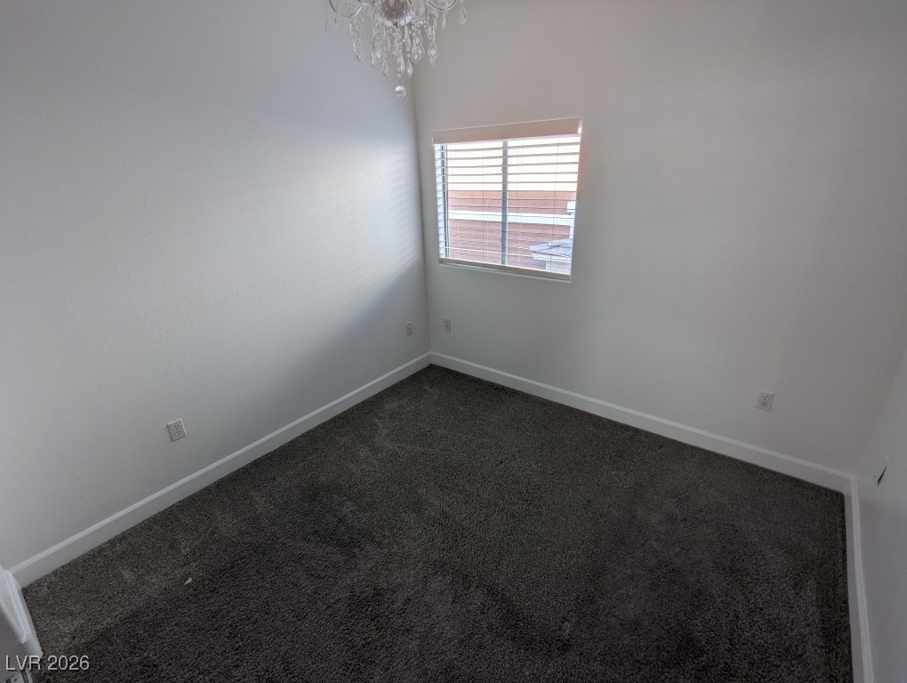 9303 Gilcrease Avenue, Unit 1137 Las Vegas, NV 89149 - Photo 24 of 30 Unfurnished room with dark colored carpet and a chandelier
