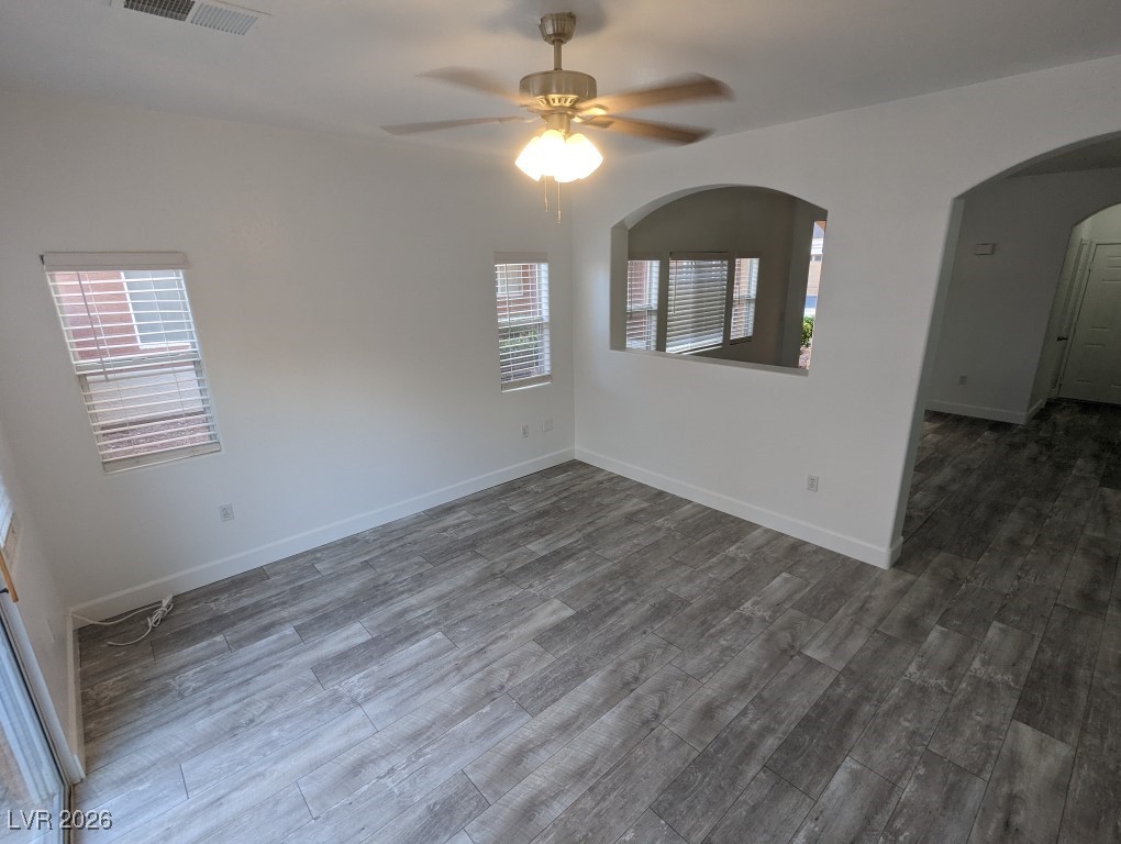 9303 Gilcrease Avenue, Unit 1137 Las Vegas, NV 89149 - Photo 7 of 30 Unfurnished room featuring dark wood-type flooring, arched walkways, and a ceiling fan
