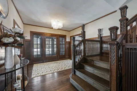 a dining room with furniture wooden floor a chandelier and a rug