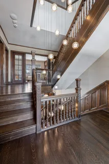 a view of a hallway with wooden floor and windows