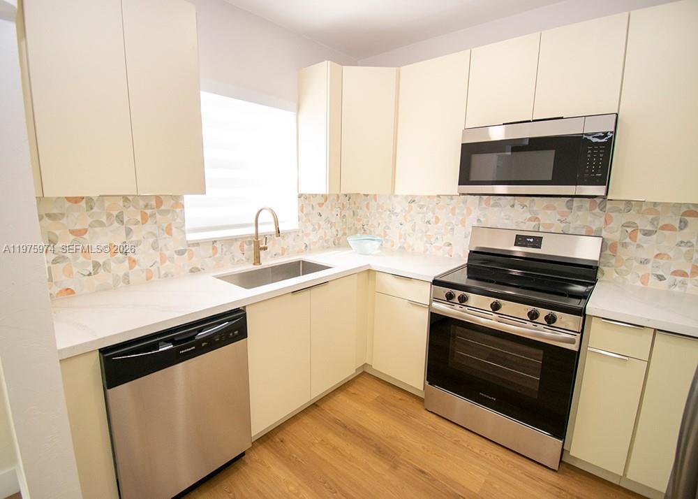 3200 Southwest 2nd Street Miami, FL 33135 - Photo 5 of 10 a kitchen with stainless steel appliances a stove a microwave sink and cabinets