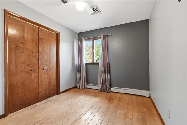 an empty room with windows and ceiling fan