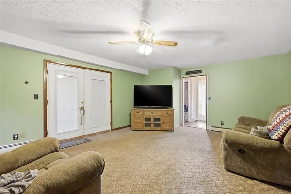 a living room with furniture a ceiling fan and a window