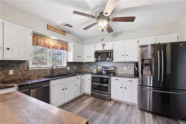 a kitchen with stainless steel appliances white cabinets and a refrigerator