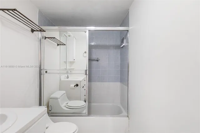 a bathroom with a tub shower sink vanity and toilet