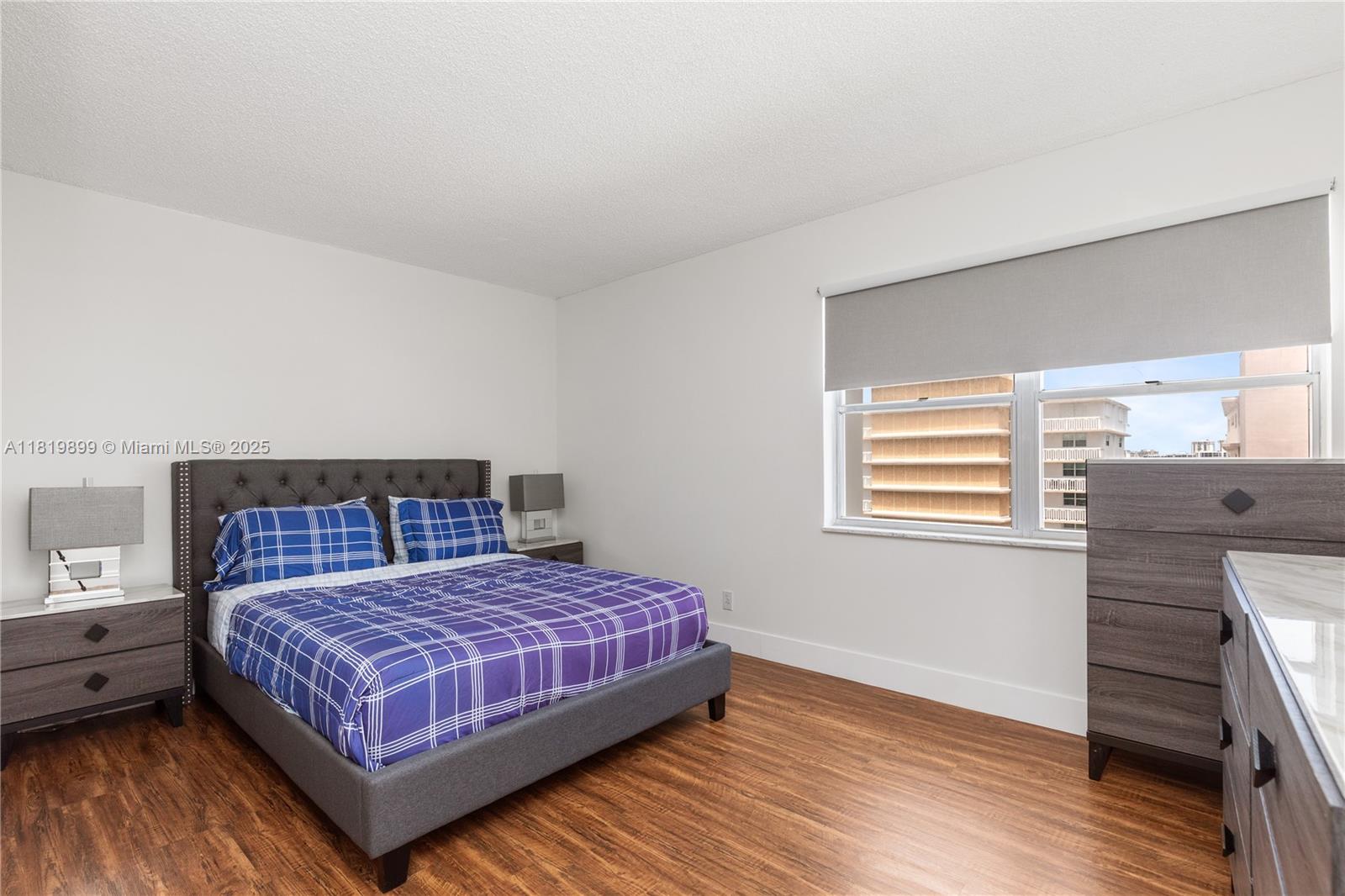 401 Golden Isles Drive, Unit 613 Hallandale Beach, FL 33009 - Photo 20 of 39 a bedroom with a bed and wooden floor