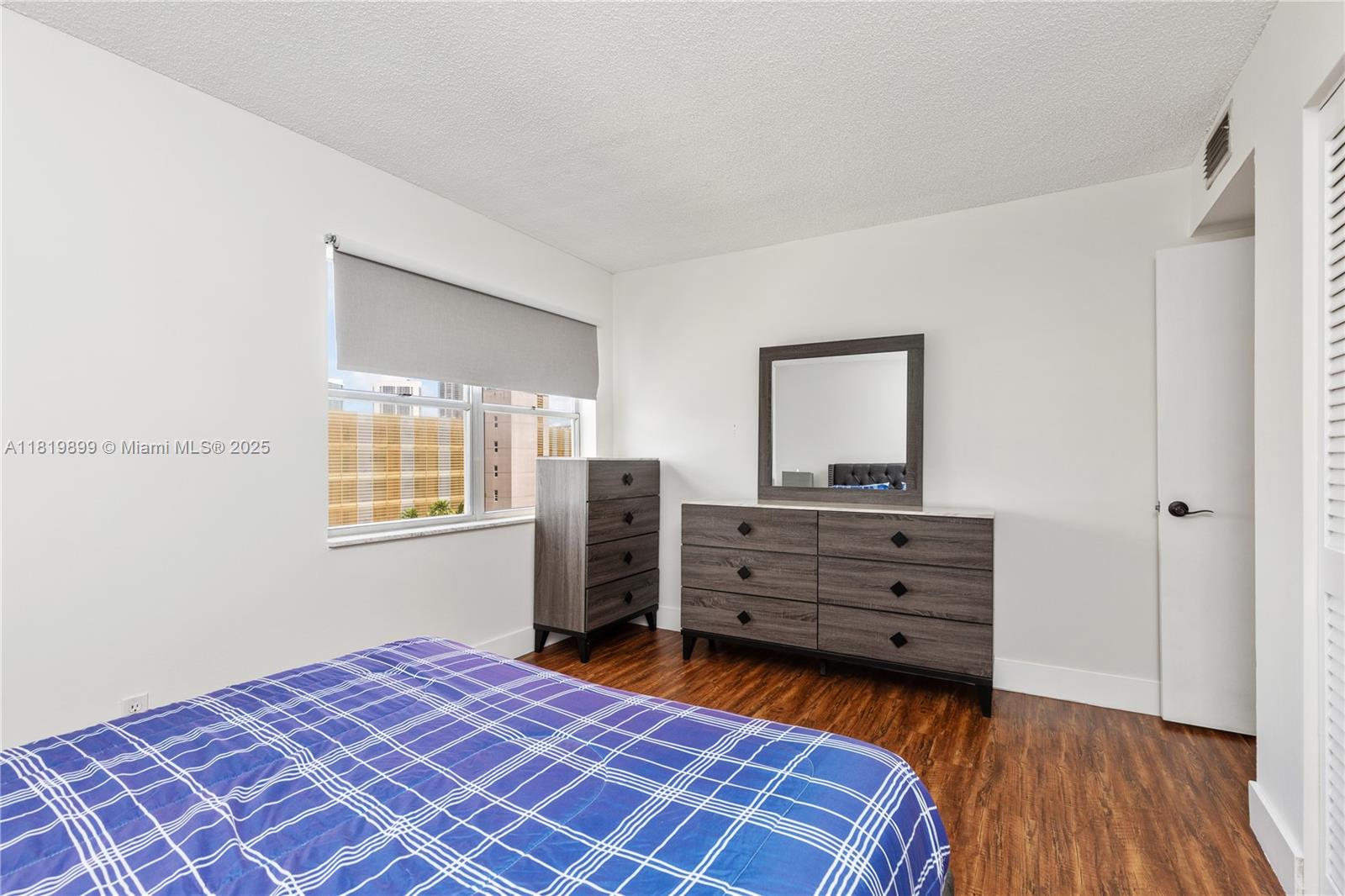 401 Golden Isles Drive, Unit 613 Hallandale Beach, FL 33009 - Photo 21 of 39 a bedroom with a bed and a dresser