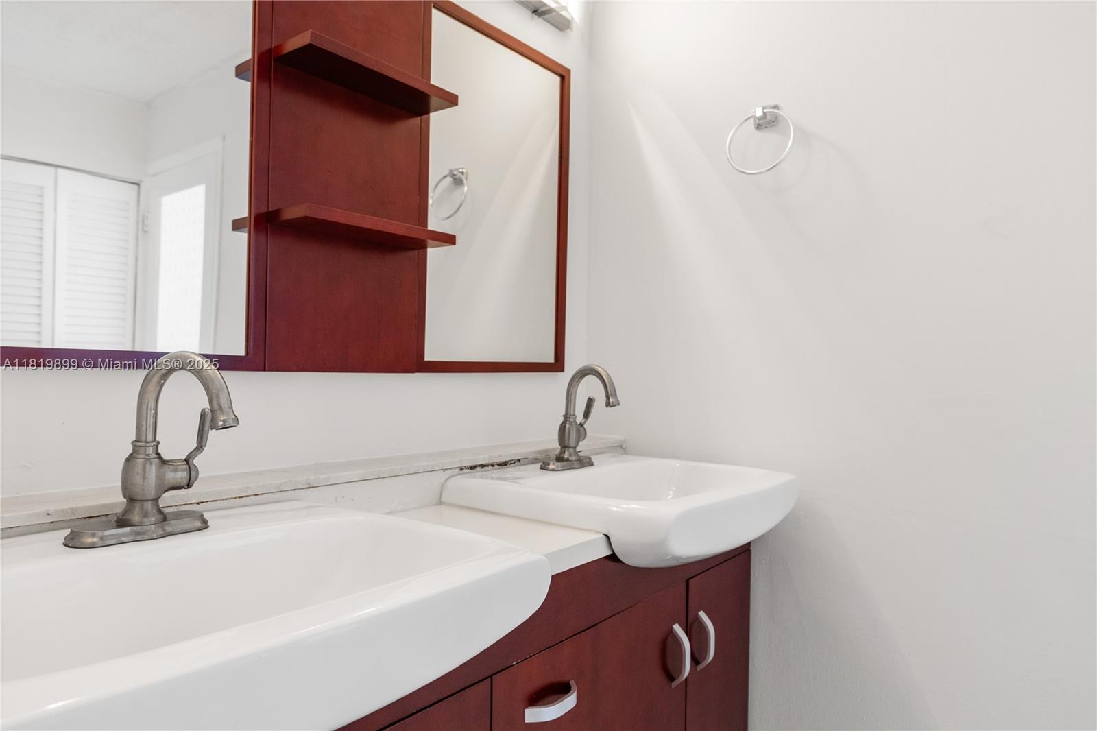 401 Golden Isles Drive, Unit 613 Hallandale Beach, FL 33009 - Photo 27 of 39 a bathroom with a sink and a mirror