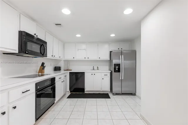 a kitchen with a sink a stove a refrigerator and cabinets