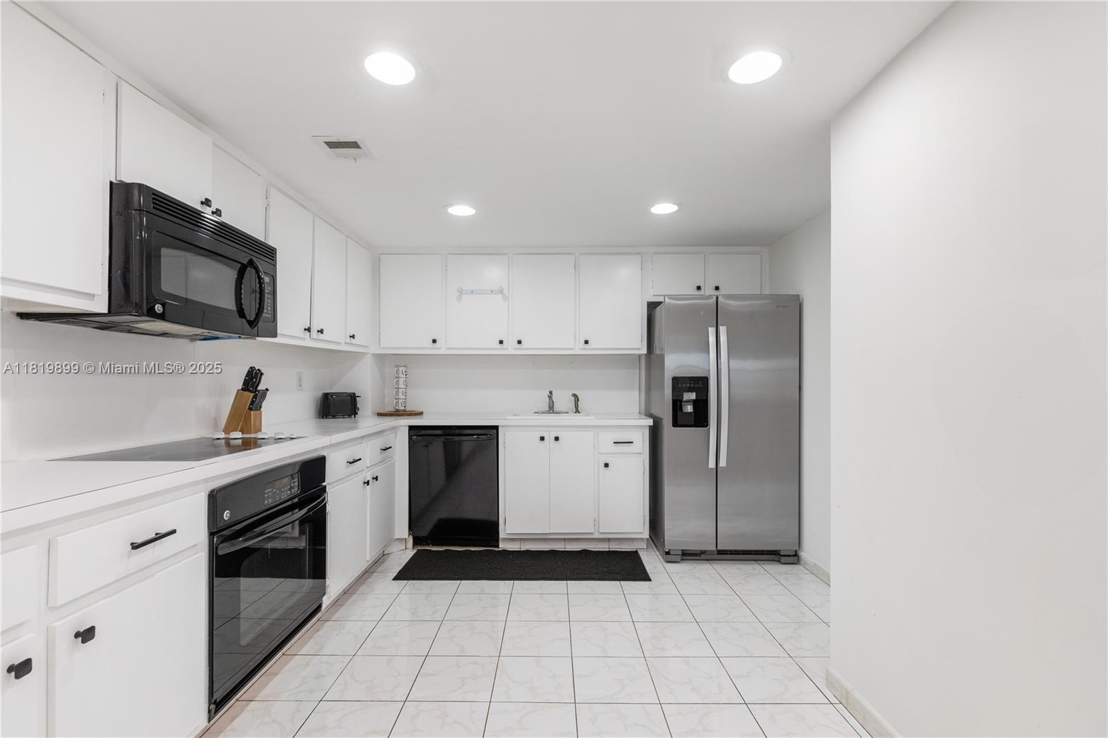 401 Golden Isles Drive, Unit 613 Hallandale Beach, FL 33009 - Photo 29 of 39 a kitchen with a sink a stove a refrigerator and cabinets