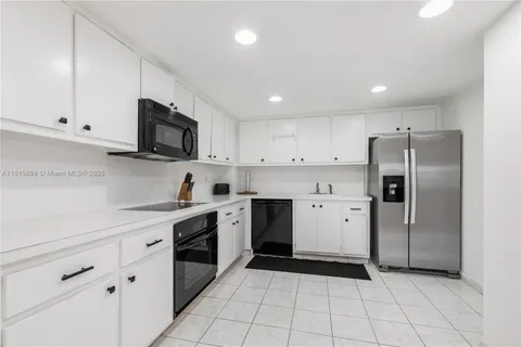 a kitchen with a sink a stove a refrigerator and cabinets