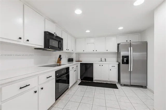 a kitchen with a sink a stove a refrigerator and cabinets