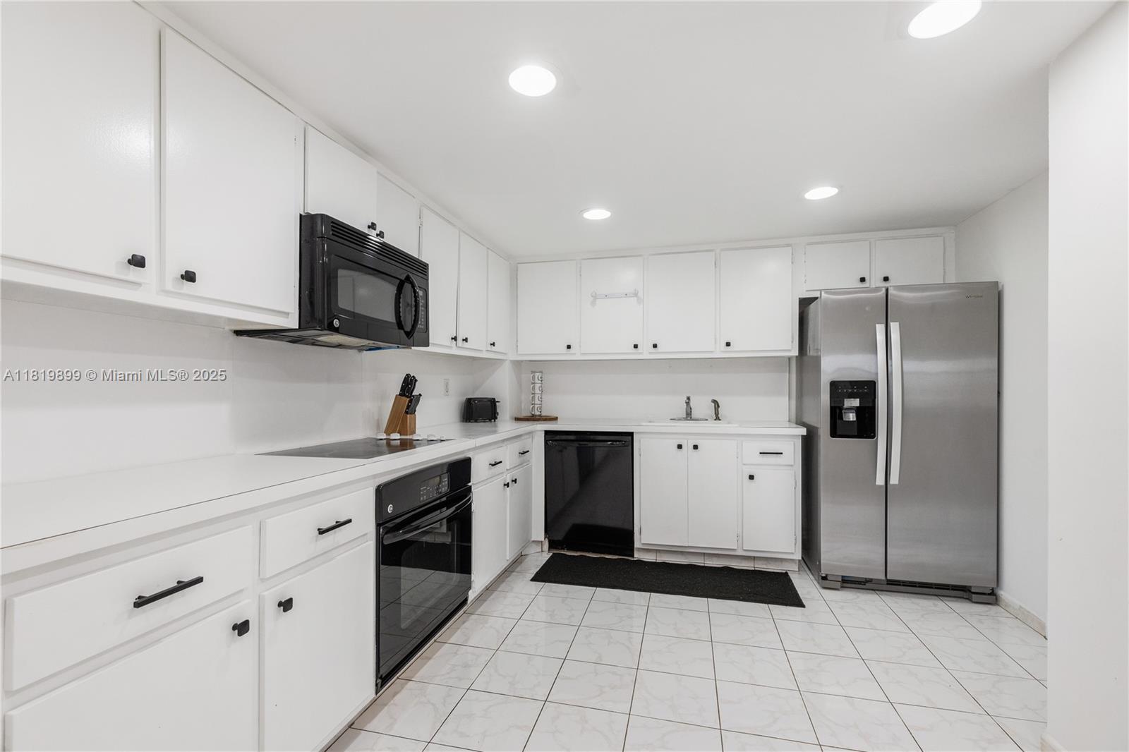 401 Golden Isles Drive, Unit 613 Hallandale Beach, FL 33009 - Photo 30 of 39 a kitchen with a sink a stove a refrigerator and cabinets