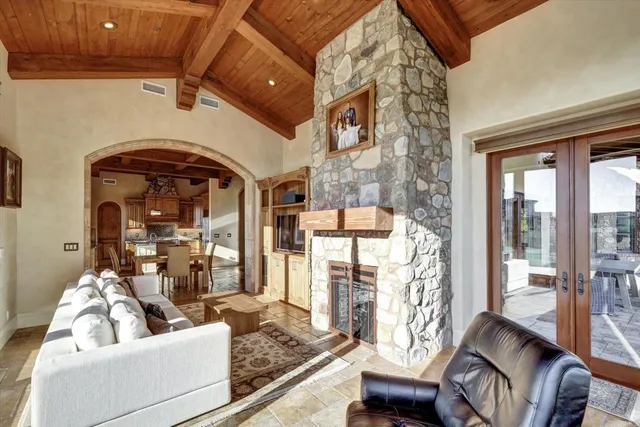 a bedroom with a bed couch and large windows