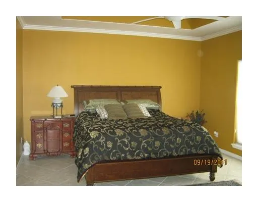 a bed sitting in a bedroom next to a lamp