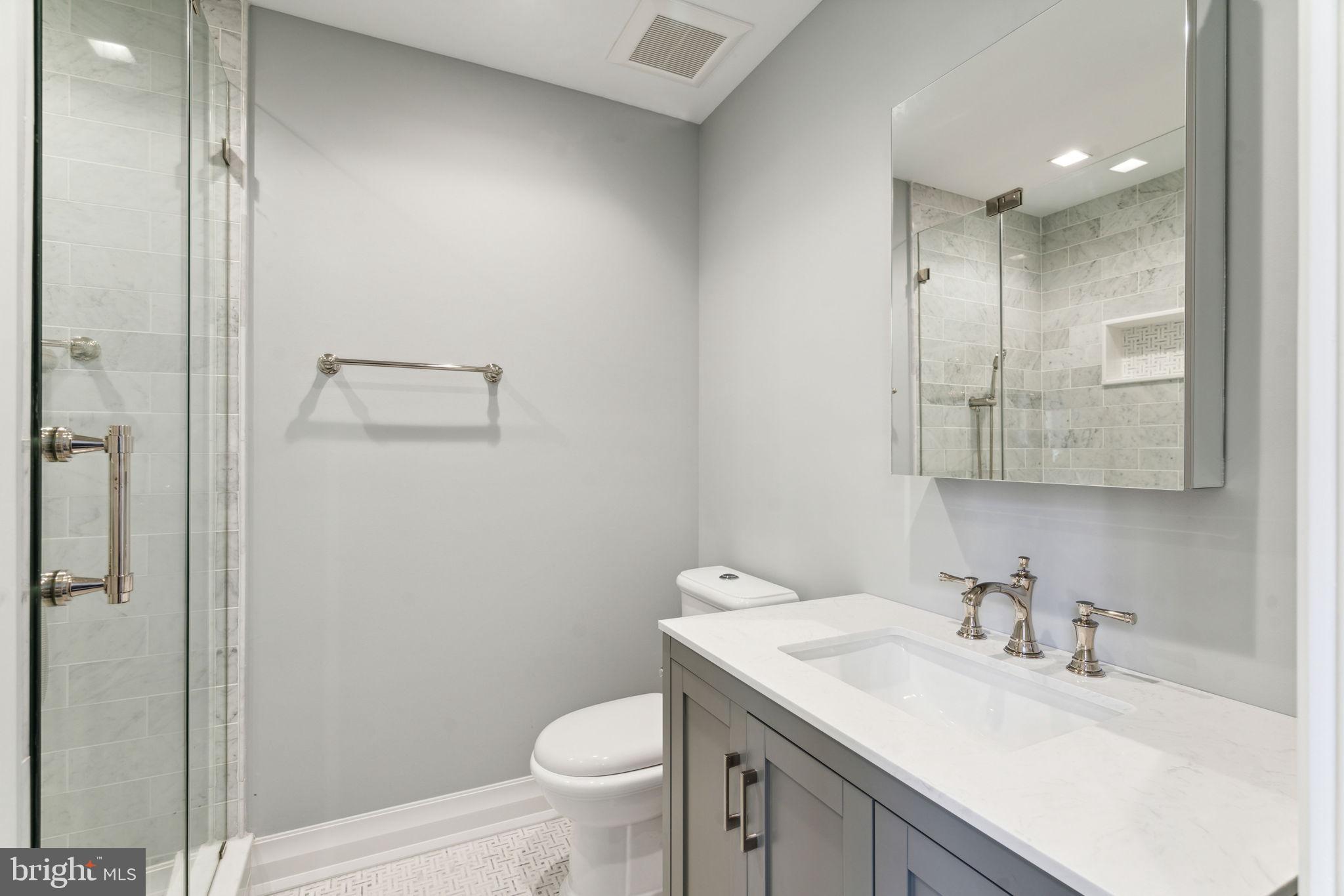 1601 Locust Street, Unit 1300 Philadelphia, PA 19102 - Photo 31 of 45 a bathroom with a granite countertop sink a toilet and a mirror