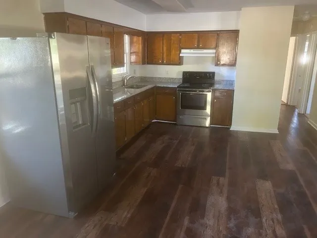 a kitchen with stainless steel appliances granite countertop a refrigerator and a sink