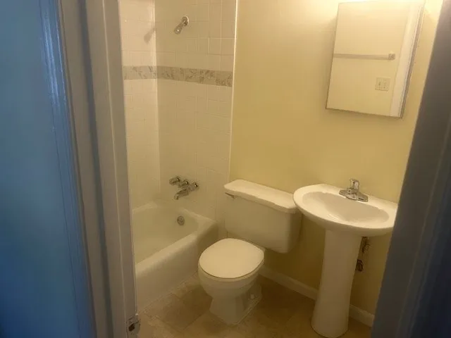 a white toilet sitting next to a bathroom sink