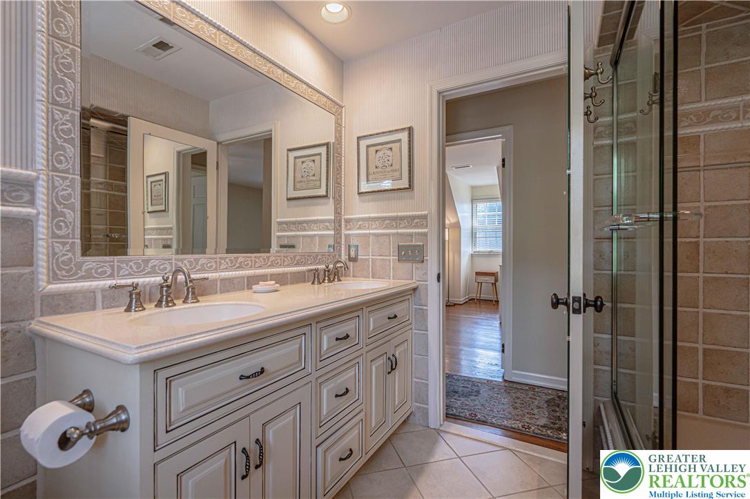 1825 Sherwood Road Allentown, PA 18103 - Photo 48 of 67 a bathroom with a granite countertop sink a mirror and shower