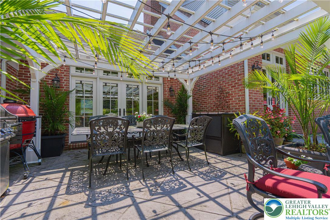 1825 Sherwood Road Allentown, PA 18103 - Photo 56 of 67 a view of a patio with table and chairs potted plants and palm trees