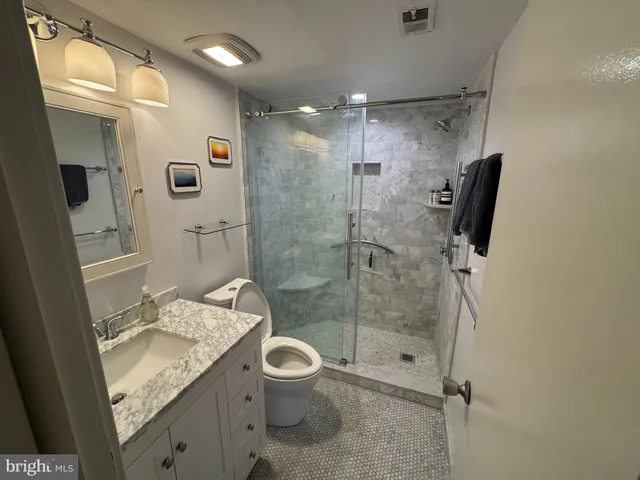 a bathroom with a granite countertop sink toilet and shower